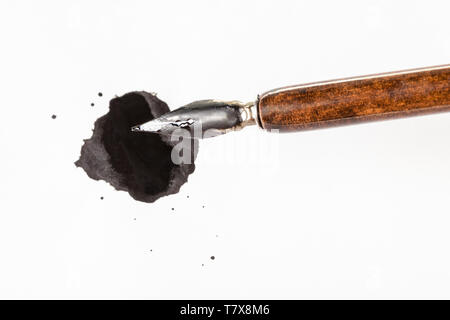 Blick von oben auf die braunen nib Stift über schwarze Tinte Fleck auf weissem Papier Stockfoto