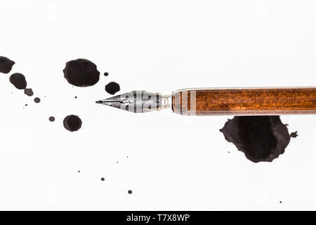 Blick von oben auf die braunen Dip Pen und schwarze Tinte Flecken auf weißem Papier Stockfoto