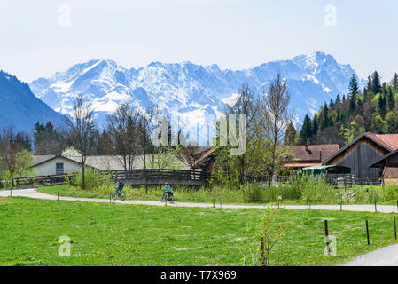 Radfahrer vor dem Frühling - wie Kulisse der bayerischen Alpen in der Nähe von Eschenlohe im Loisachtal Stockfoto