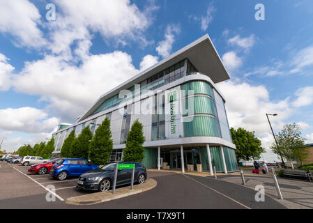 Eine Familie von Fahrgästen in Richtung Flughafen London Southend aus dem Holiday Inn Hotel, Southend On Sea, Essex, Großbritannien. Flugreisen Unterkunft Stockfoto