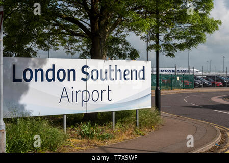 Schild zum Flughafen London Southend mit dem Flugzeug von Ryanair dahinter. Southend on Sea, Essex, Großbritannien. Parkplatz. Autos. Parken Stockfoto