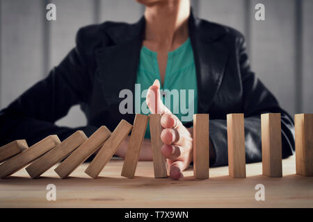 Geschäftsfrau hält eine Kette fallen wie Domino Spiel. Konzept zur Vermeidung der Krise und Ausfall im Geschäft. Stockfoto