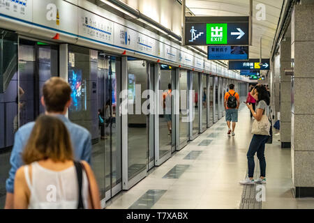 Hongkong, China - Passagiere warten auf den Zug in die U-Bahn Station Stockfoto