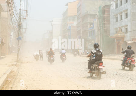 KATHMANDU, Nepal - 9 Mai, 2019: Verkehr auf Boudha Straße Staub in der Luft als die Straße ist nicht blacktopped. Es ist ein ständiges Problem für den Bereich resid Stockfoto