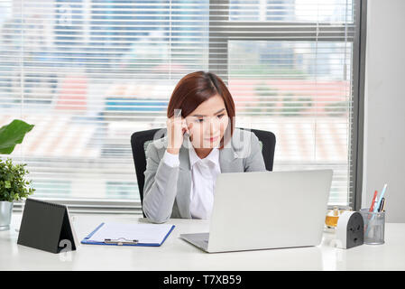 Betonte Depressiven jungen asiatischen Business Frau mit Laptop Probleme leiden. Stockfoto