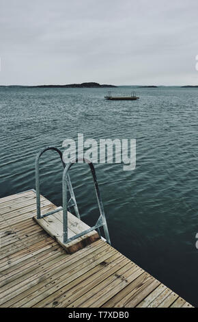 Eine leere schwimmen Plattform/Ponton an einem bewölkten Tag an der Küste von Schweden Stockfoto