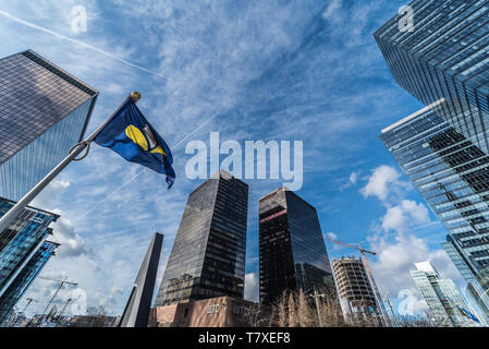 Brüssel, Belgien - 03 10 2019: moderne Wolkenkratzer aus Glas und Stahl der Kleinen Manhattan Business Bezirk mit einem Brüssel Iris Flagge Stockfoto