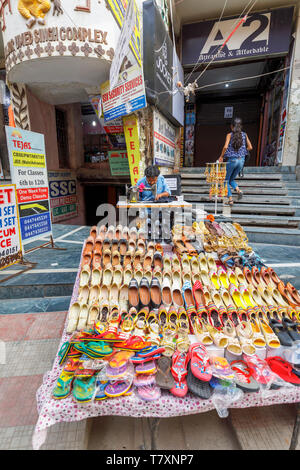 Straßenszene in Mahipalpur Bezirk, einem Vorort in der Nähe von Delhi Flughafen in New Delhi, die Hauptstadt Indiens: lokale Mann bei der Arbeit mit einem manuellen Nähmaschine Stockfoto