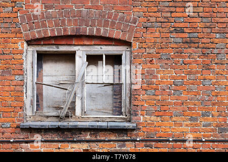 Alte Fenster gesperrt mit gebrochenen Holzrahmen in grungy brick wall, Hintergrund Foto Textur Stockfoto