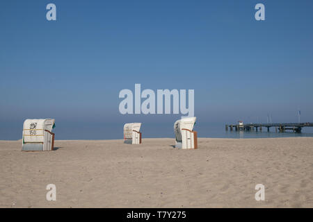 Drei Strandkörben auf menschenleeren Sandstrand unter blauem Himmel in Dahme Deutschland Stockfoto