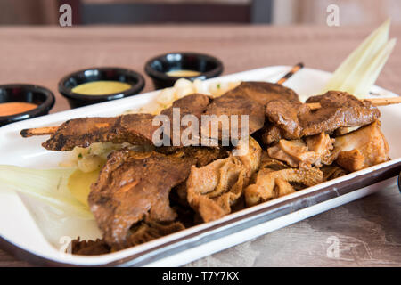 Traditionelle peruanische Küche "Anticuchos" gegrillte aufgespießt Rinderherz Fleisch am Grill zubereitet Stockfoto