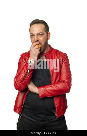 Cool Mann in Rot Leder Jacke ist Essen ein Apple Stockfoto