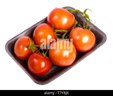 Reife rote Tomaten in einem dunklen Kunststoff Fach auf einem weißen Stockfoto