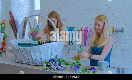 Zwei Frauen, Floristen, großen floralen Korb mit Blumen Flower Shop Stockfoto