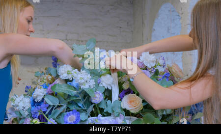 Zwei Frauen, Floristen, großen floralen Korb mit Blumen Flower Shop Stockfoto