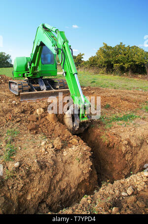 Ausgrabungen in einen Graben mit einem Bagger. Stockfoto