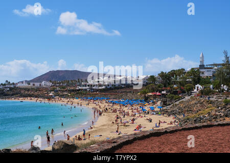 Playa Blanca, Lanzarote, Spanien - 24 April 2019: Touristen genießen Sie einen Tag am Strand von Playa Dorada auf Lanzarote, im Winter eine bevorzugte Destination Stockfoto