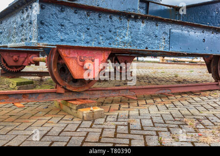 Alt und rostet Waggon mit dunkelblauen Bügeleisen Karosserie und rosten Zahnräder als mobile Plattform für eine kleine Kran, Ayrshire, Schottland verwendet Stockfoto