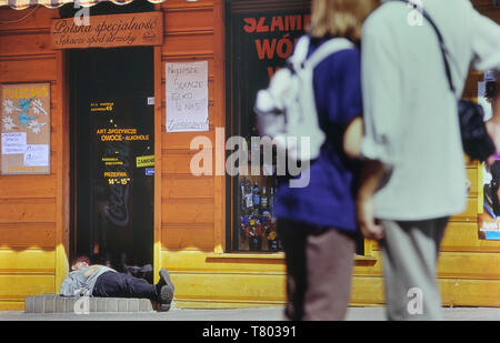 Ein Mann der schläft in der Tür eines Wodka store. Zakopane. Polen. Stockfoto