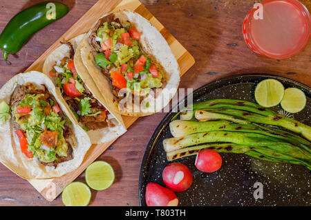 Mexikanische Tacos, gegrillte carne asada Tacos mit Radieschen, Limes, Frühlingszwiebeln, Limonade und Gewürze. Stockfoto