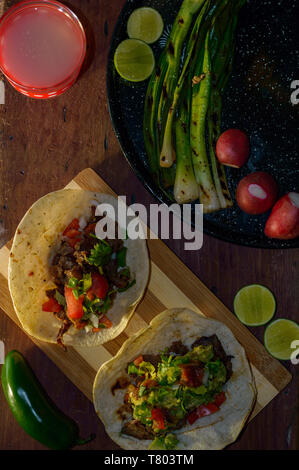 Tijuana Tacos, gegrillte carne asada mit Radieschen, Limes, Frühlingszwiebeln, Limonade und Gewürze. Wenig Licht mit Kopie Raum Stockfoto