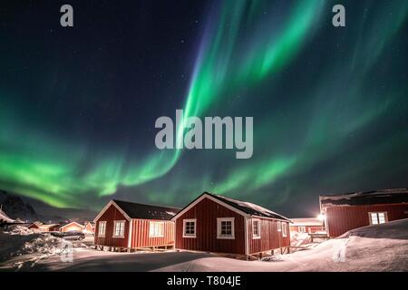 Nordlichter (Aurora Borealis) über Rorbuer Hütten im Winter, Hamnoy, Moskenesoya, Lofoten, Norwegen Stockfoto