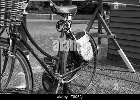 Schwarz-weiß Nahaufnahme von ARP Wardens Oldtimer-Fahrrad (Bike) mit Frontkorb & ARP-Tasche, isoliert am UK Heritage Railway Station, 40er-Veranstaltung. Stockfoto