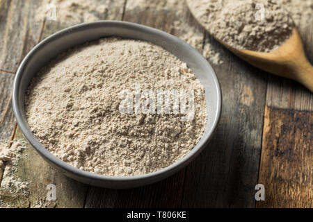 Organisches Ganzes Weizenmehl in eine Schüssel geben. Stockfoto