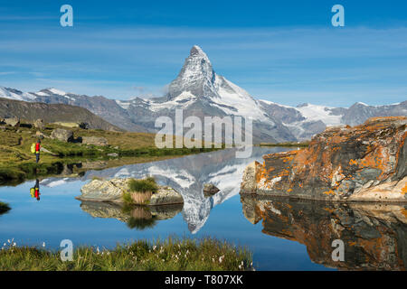 Ein Wanderer Wandern in den Alpen nimmt im Blick auf das Matterhorn in Stellisee See in der Dämmerung wider, Schweizer Alpen, Schweiz, Europa Stockfoto