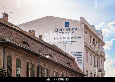 Sibiu, Rumänien - 22. April 2019: Hotel Continental Forum Sibiu neben einem alten architektonischen Stil Gebäude mit Windows wie Augen, wie aus gesehen Stockfoto