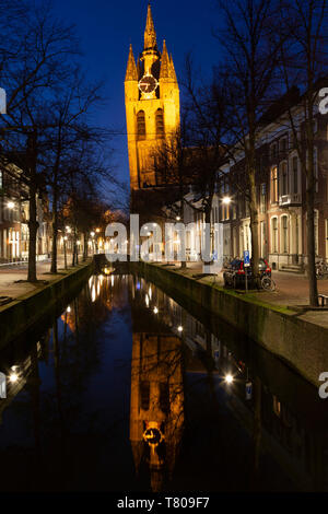 Die Oude Kerk der Schiefe Turm (Oude Jan) (scheve Jan) spiegelt sich in der Nacht in der Oude Delft Kanal in Delft, Südholland, Niederlande, Europa Stockfoto