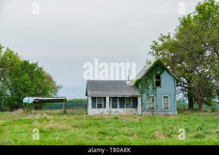 Altes verfallenes verlassenes, mit Weinreben bedecktes Bauernhaus im ländlichen Kentucky, USA. Stockfoto