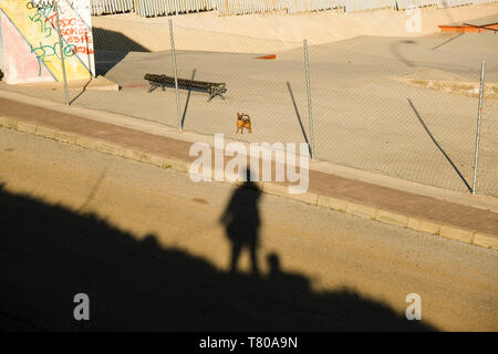 Abstrakte Ansicht mit Schatten des Fotografen und kleiner Hund in Ronda, Provinz Málaga, Andalusien, Spanien. Stockfoto