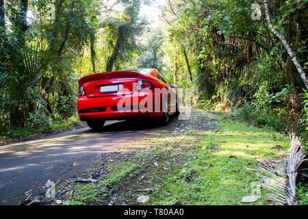 Red Holden Monaro HSV Coupe II 2003 GTO, Opel, Pontiac GTO, Chevrolet Lumina Coupé. Scenic Drive, Waitakere Ranges, Pukematekeo. Glänzend Sportwagen. Stockfoto
