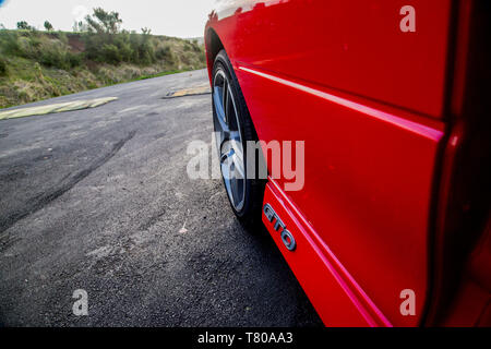 Red Holden Monaro HSV Coupe II 2003 GTO, Opel, Pontiac GTO, Chevrolet Lumina Coupé. Scenic Drive, Waitakere Ranges, Pukematekeo. Glänzend Sportwagen. Stockfoto