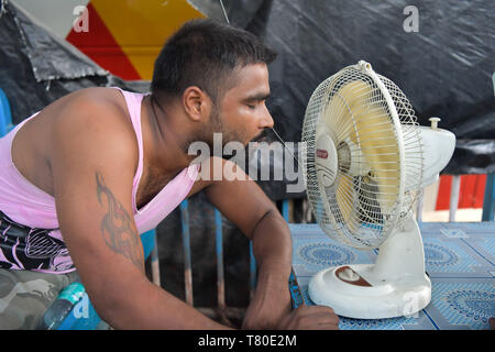 Kolkata, West Bengal, Indien. 9. Mai, 2019. Ein Mann wird gesehen, eine Pause von der Arbeit selbst Abkühlung durch einen Ständer Lüfter. Mit maximaler Temperatur bei 39 Â°C, hoher Luftfeuchtigkeit und Hitze aus dem zentralen Indien und Chhotanagpur, Unannehmlichkeit index schießt auf die Saison hoch in Kolkata und anderen Bezirken von West Bengalen, Indien. Unannehmlichkeit Index bei 67,6, höchste dieses Sommers. Credit: Avijit Ghosh/SOPA Images/ZUMA Draht/Alamy leben Nachrichten Stockfoto