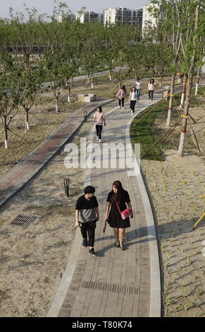 (190510) - Peking, 10. Mai 2019 (Xinhua) - die Leute machen einen Spaziergang im Park in Wutong Yizhuang, Peking, am 9. Mai 2019. Das neu gebaute Wutong Park, der war früher eine alte Großmarkt, wurde offiziell der Öffentlichkeit am Donnerstag eröffnet. (Xinhua / Li Xin) Stockfoto