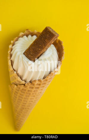 Vanille Eis in der Waffel Kegel mit Schokolade auf gelbem Hintergrund, kopieren Raum Stockfoto