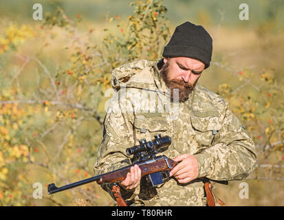 Mann Jäger mit Gewehr Pistole. Boot Camp. Bärtiger Mann Jäger. Die Streitkräfte. Camouflage. Uniform Mode. Jagd Fähigkeiten und Waffen Ausrüstung. Wie schalten Sie die Jagd in Hobby. Cowboy mit Gewehr. Stockfoto