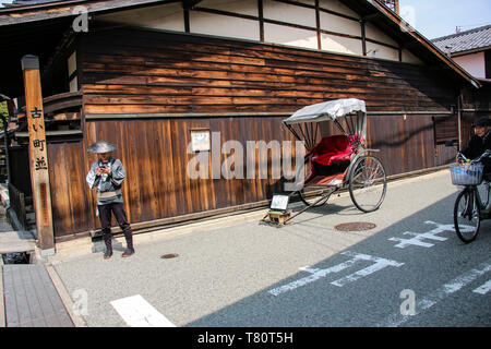 TAKAYAMA, Japan - 27. MÄRZ 2019: traditionelle Stadt scape von Takayama - Warenkorb und rikscha Für die Reisenden zu Fuß auf den alten Straßen Takayama, Gifu pr Stockfoto