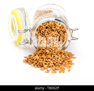 Golden Leinsamen. Mikronährstoff vorteilhaft für den Organismus, verhindert und heilt Erkrankungen. In Glas Glas auf weißem Hintergrund. Reich an Ballaststoffen und Mutter Stockfoto
