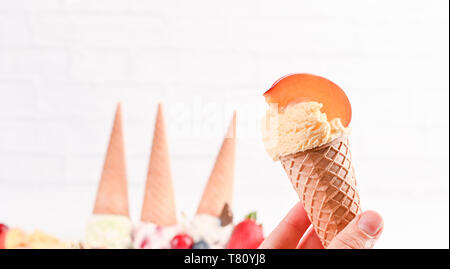 Süßes Eis in Kugeln auf einem weißen Hintergrund. Dessert mit verschiedenen Geschmacksrichtungen und frischen Beeren. Eis in der Waffel Kegel. Platz kopieren Stockfoto