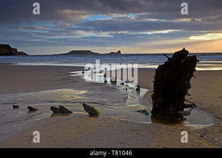 Sonnenuntergang über dem Wrack der Helvetia und Würmer Kopf an Rhossili Bay, Gower, Wales, Vereinigtes Königreich, Europa Stockfoto