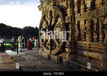 Touristen bei Sonnenuntergang von der 24 geschnitzten riesigen Stein Wagenräder geschnitzt auf 13. Jahrhundert Konark Sonnentempel, UNESCO, Odisha, Indien, Asien Stockfoto