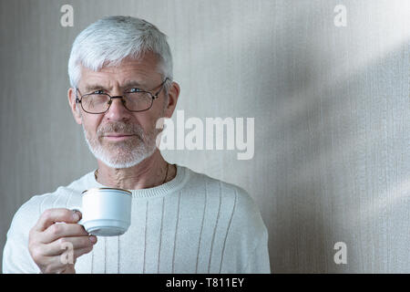 Porträt der grauhaarige Mann mit einer Tasse Kaffee Stockfoto
