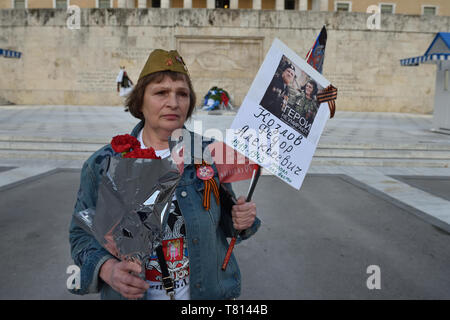 Athen, Griechenland. 9. Mai 2019. Eine Frau stellt vor dem Denkmal des unbekannten Soldaten, wie sie Teil in der Unsterblichen Regiment Prozession findet während der Tag des Sieges Feiern zum 74. Jahrestag des Sieges über Nazi-Deutschland zu markieren und die russischen Opfer im Zweiten Weltkrieg in Athen, Griechenland, gedenken. Credit: Nicolas Koutsokostas/Alamy Stock Foto. Stockfoto