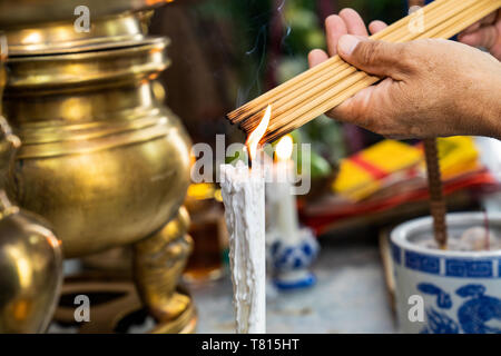 Mann hält eine Menge Weihrauch nach Feuer in all das. Stockfoto