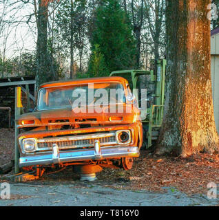 Ein Lkw ruht in viel abgebrochen wurden, während Sie den Sonnenuntergang sein Rost mehr Prominente macht. Es hat schon bessere Tage gesehen. Stockfoto