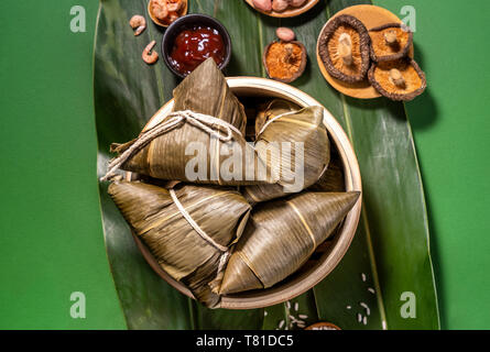 Zongzi, gedämpftem Reis Knödel am grünen Tisch Hintergrund, Essen im Drachenboot Festival duanwu Konzept, Nahaufnahme, Kopieren, Ansicht von oben, flach Stockfoto