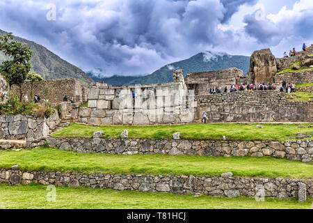 Machu Picchu, Peru - April 6, 2019: Touristen besuchen Tempel der drei Fenster und Heilige Plaza in der alten Stadt der Inkas nach Machu Picchu, Peru. Stockfoto